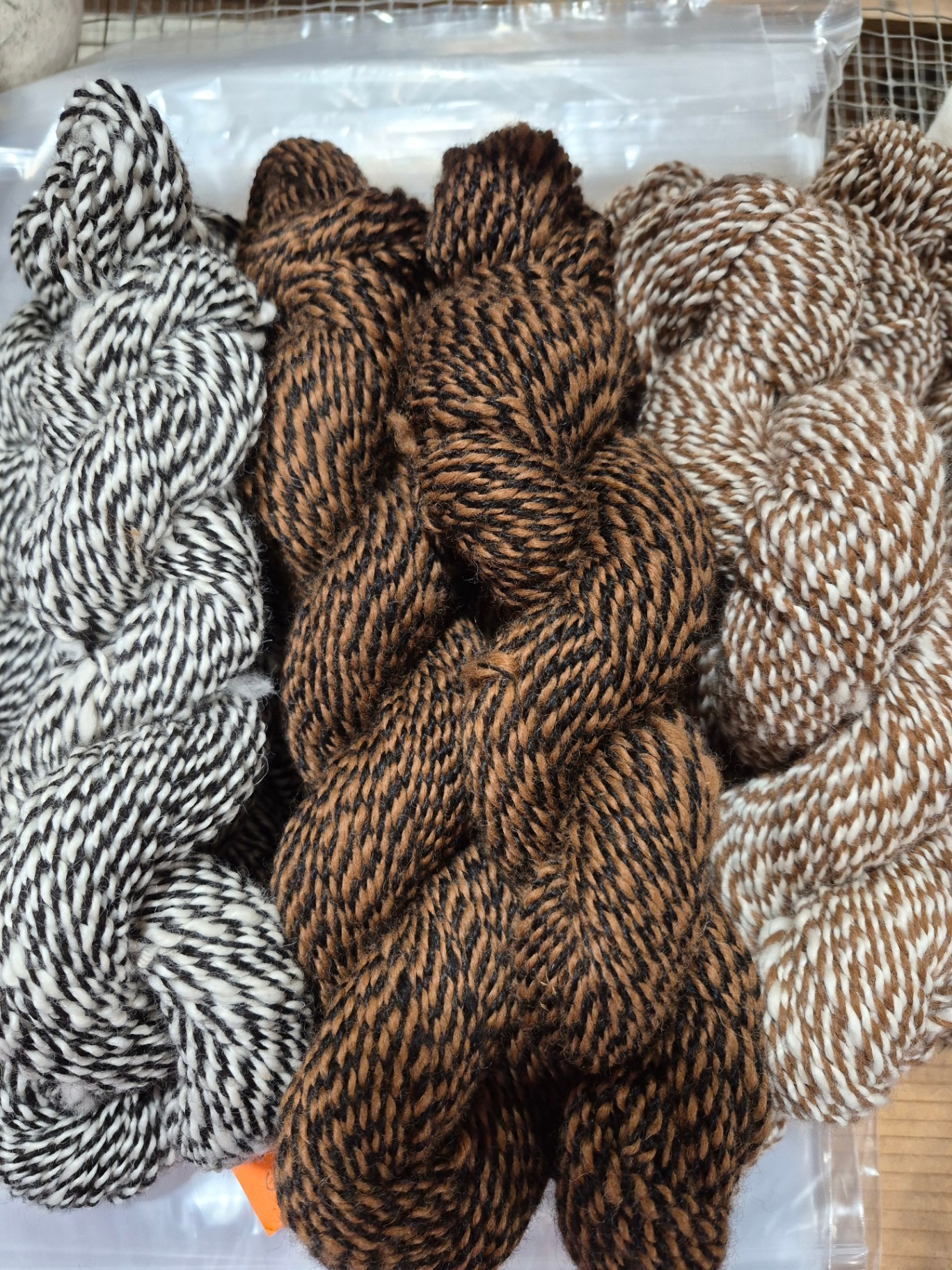 Marled two-ply skeins in natural black, white, and fawn alpaca